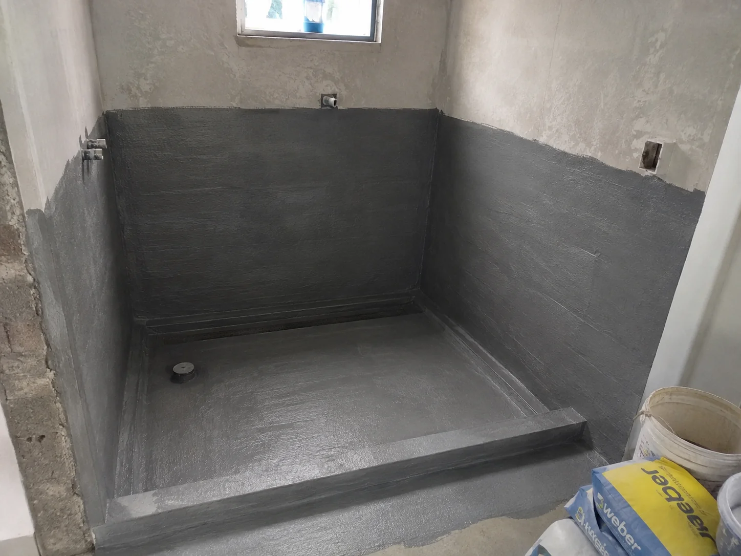 Detailed waterproofing preparation in a bathroom construction site